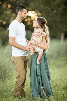 a man and woman holding a baby in their arms