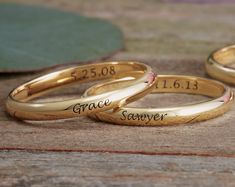 two gold wedding rings with names engraved on them