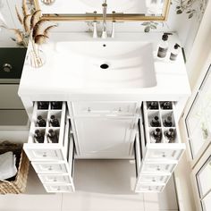 a white sink sitting under a mirror next to a counter top with drawers underneath it