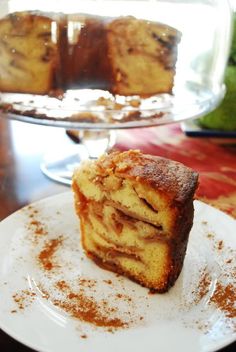 a piece of cake sitting on top of a white plate next to a glass dish