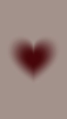 a red heart shaped object on a gray background with the light reflecting off it's side