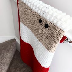 a crocheted christmas stocking hanging on the side of a stair case next to a handrail