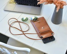 a cell phone and sunglasses on a table next to a laptop