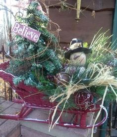 a red sleigh filled with lots of plants