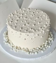 there is a white cake with pearls on it