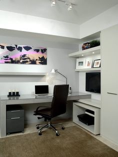 an office with a desk, chair and computer on top of the desk is shown