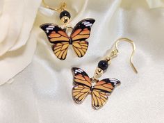 These dainty butterfly earrings, will make a whimsical addition to your jewelry collection. They will add a pretty pop of color, to brighten your day! Product details: * Gold plated ear wires; Lead and nickel free * Black glass beads * Gold plated beads * Gold plated butterfly charm * Handmade, with lots of love and care! - Length:  1.25 inches - Width:    .75 inches ❤ To see more unique jewelry from Flutterbird Co, click my shop link below. ❤   https://www.etsy.com/shop/FlutterbirdCo My goal is to provide every customer with exceptional service. Please message me if you have any questions. Thank you for supporting my small business! Orange Butterfly Jewelry For Gifts, Orange Butterfly Jewelry Gift, Orange Butterfly-shaped Jewelry Gift, Butterfly Charm Drop Earrings For Gift, Butterfly Charm Drop Earrings As Gift, Adjustable Drop Earrings With Butterfly Charm, Nickel-free Adjustable Butterfly Earrings, Black Butterfly-shaped Jewelry For Gift, Black Butterfly Jewelry For Gift