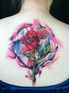 a woman's back with a rose tattoo on it