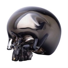 a black and silver skull sculpture on a white background