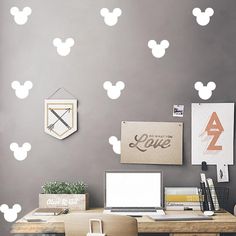 a desk with a laptop and mouse decals on the wall