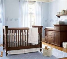 a baby's room with blue walls and wooden furniture, including a crib