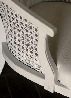 a close up view of the back of a white chair with an intricate design on it