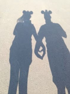 two people are holding hands in the shadow