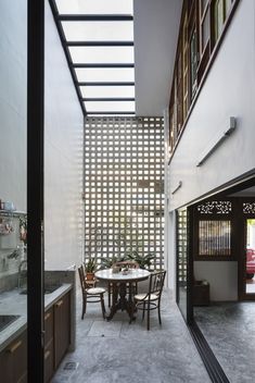 a person sitting at a table in a room with glass walls on the outside wall