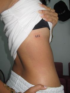 a woman with a small tattoo on her lower back and the number forty four behind her