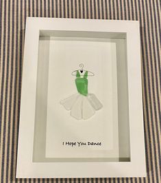 a white frame with a green and white dress in it that says i hope you dance