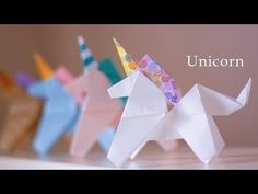 three origami unicorns sitting next to each other on top of a table