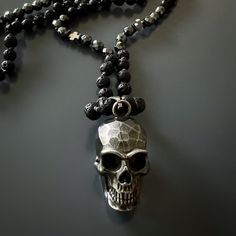 The Silver Skull Pendant Black Lava Rock Stone Beaded Necklace is a striking piece of handmade jewelry that combines the raw energy of lava rock stone and the powerful properties of hematite stone. The unique necklace features black lava rock stone beads, which are believed to have calming and grounding effects on the emotions. These beads originate from raw energy and are among the oldest stones in the world. Many individuals who wear lava stone believe that it helps to stabilize and ground the Black Lava Stone Jewelry For Healing, Black Lava Stone Spiritual Jewelry, Black Skull Necklace With Oxidized Finish, Unique Handmade Skull Necklace, Handmade Gothic Skull Necklace, Necklace Displays, Skull Pendant Necklace, Edgy Accessories, Hematite Stone