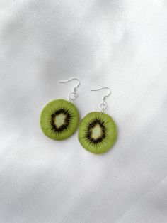 "Kiwi slice ornament fun food earrings Include : 1 pair of earrings These earrings are made out of felt fabric. ○ Lenght  : 2.3'' (with hook) 1.35\"x 1.25\"(the kiwi ) ○ Color : green ○ Materials :  earring hook, felt fabric, sublimation ink,  metal ring, glue ○ Design and made in Latvia ♥ If you need any costumized items, please contact me. Kiwi earrings, Fun food earrings, Kiwi jewelry, Kiwi ornament, Gift for teenager , Snack earrings, Funny fruit earrings, Kiwi charm, Fruit ornaments, The co Kiwi Inspired Outfits, Kiwi Outfit, Kiwi Aesthetic, Random Earrings, Fun Earrings Unique, Kiwi Earrings, Kiwi Slice, Silly Earrings, Earrings Funny