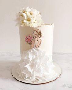 a wedding cake with white flowers on top and a bride's dress painted on the side