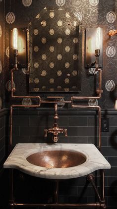 a bathroom sink sitting under a mirror in front of a wall mounted faucet