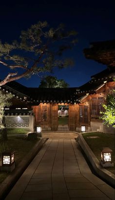 an outdoor walkway lit up at night with lanterns