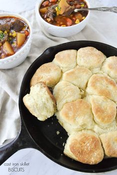 a cast iron skillet filled with biscuits and stew