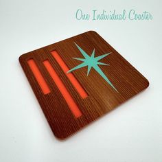 a wooden cutting board with an orange and green design on it that says one individual coaster