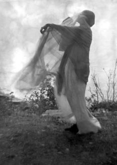 an old black and white photo of a person holding something