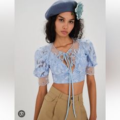 Spring Blues. Organza Embroidery Detachable Collar Low Neckline Puff Sleeve With Scalloped Trim Invisible Zip Closure Partially Lined Fabric + Care Self: 60%Nylon/37%Cotton/3%Tencel; Lining: 98% Recycled Polyester/2% Spandex Measurements Bust:30” Waist:24” Length:15.5” Blue Floral Embroidery Tops For Wedding, Blue Floral Embroidered Tops For Wedding, Blue Lace Tops For Spring, Fitted Light Blue Lace Tops, Blue Lace Short Sleeve Top, Blue Lace Top With Short Sleeves, Blue Tops For Summer Wedding, Blue Lace Crop Top, Collar Crop Top