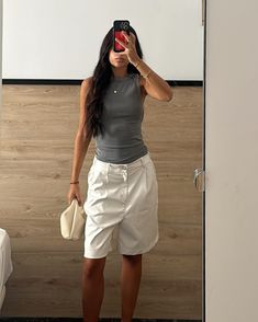 Bianca Barese wears a minimalist outfit featuring a gray tank top and white Bermuda shorts, accessorized with a cream clutch. Gray Tank Outfit, Gray Top Outfit, White Bermuda Shorts Outfit, Grey Top Outfit, Cream Clutch, Bermuda Shorts Outfit, White Bermuda Shorts, European Fashion Summer, Indie Sleaze