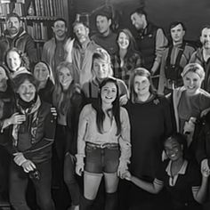 a group of people standing next to each other in front of a bookshelf