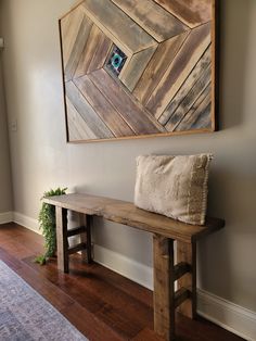 a wooden bench sitting in front of a painting on the wall