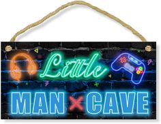 a neon sign that says little man and cave with video game controllers hanging from it