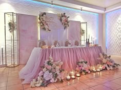 the table is set up with candles and flowers for an elegant wedding reception in pink