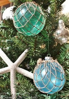 an ornament hanging from a christmas tree with starfishs and seashells