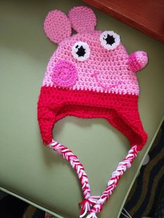 a crocheted pink and red hat with eyes