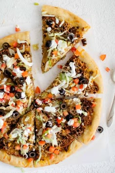 a pizza sitting on top of a white plate next to a slice of pizza with toppings