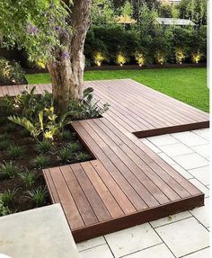 a wooden bench sitting next to a tree on top of a white tile flooring