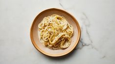 a bowl filled with noodles on top of a white counter