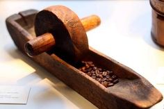 a wooden grinder filled with grains on top of a table