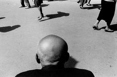 a black and white photo of people walking down the street with their feet in the air