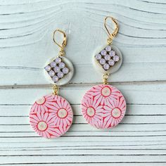 Vintage textile print in feminine pink daisy decoupaged on a disc, with the second disc in mother of pearl adorned with sparkling high-quality Swarovski bling in pink opal. Earrings have a lever back nickel free closure and a 3-inch drop. Perfect summer earrings to complete that beach outfit! Thanks for looking! Handmade Pink Circular Earrings, Handmade Pink Circle Earrings, Vintage Pink Earrings For Summer, Pink Round Earrings For Summer, Pink Round Summer Earrings, Pink Opal Earrings, Textile Print, Vintage Textile, Summer Earrings