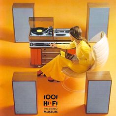 a woman sitting on top of a chair in front of a record player and turntable