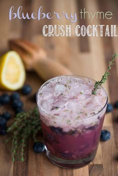 the blueberry thyme crush cocktail is garnished with fresh herbs