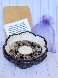 a bowl filled with sea shells next to a card and bag on a table top