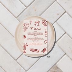 a plate with a menu on it sitting on a tile floor