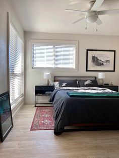 a bedroom with white walls and wooden floors