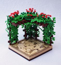 an intricately designed wooden structure with red flowers and vines on the top, in front of a white background