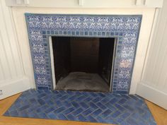 a fireplace with blue and white tiles on it